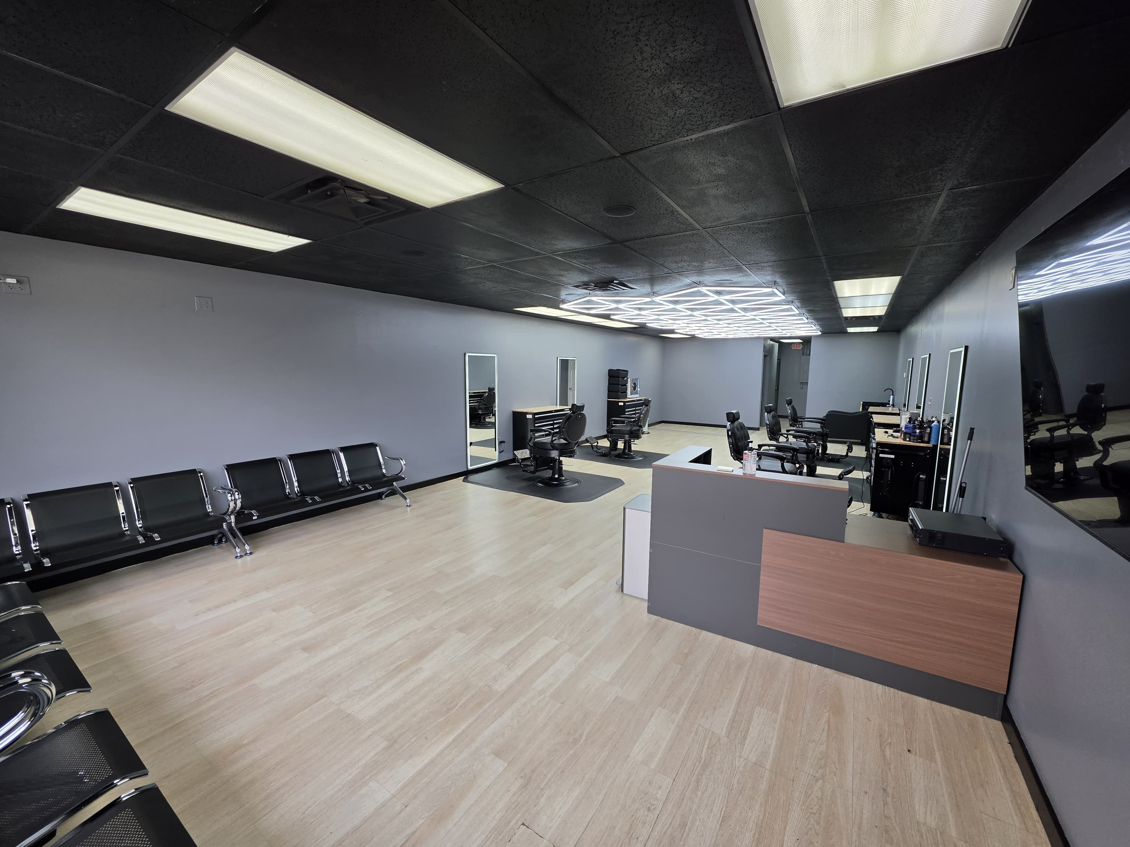 Interior of Legacy Studio Barbershop showing barber chairs and geometric ceiling lighting